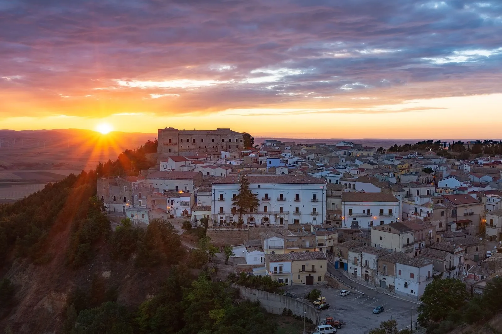 Veduta di Ascoli Satriano al tramonto con il Palazzo Ducale sulla collina e le case del centro storico